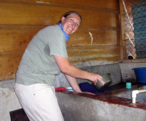 Laureen washing her clothes in a pila.