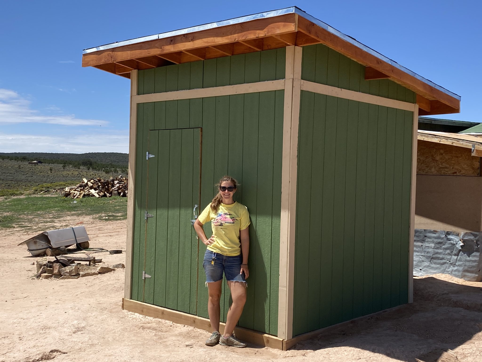 Construction Coordinator Rose Lopez stands outside of a woodshed she led with volunteer help in the Navajo Nation.